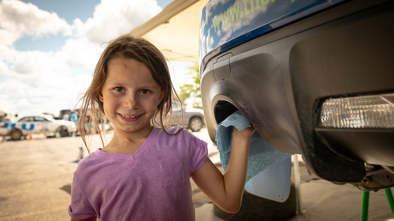 Imogen Thompson has grown up around motorsport. She is helping the TRF crew keep the cars clean at a summer rally race.